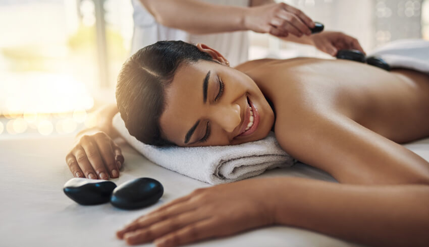 A woman receiving a hot stone massage
